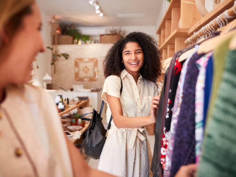 En modeälskare utforskar secondhand-kläder i en butik, letar efter unika fynd.
