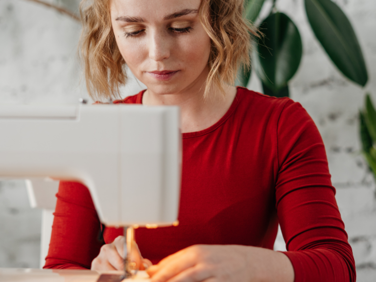 En person som skräddarsyr en secondhand-jacka.